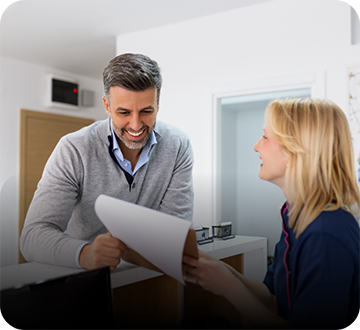 Female dental team member showing paper to male patient